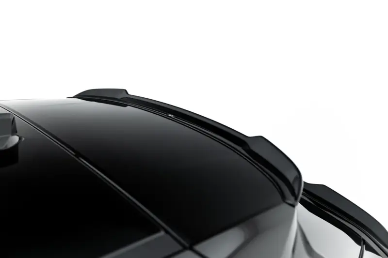 Close-up of a glossy black car roof and rear spoiler with reflections on the surface against a white background.
