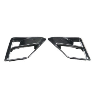 Pair of carbon-fiber car trim accents with angular rectangular openings, likely exterior decorative pieces on a vehicle relief.