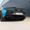 Artura_Web_CT_Carbon_170426_04jpg - OPSHOLDERS Rear view of a blue McLaren supercar with carbon fiber diffuser and twin exhausts, CT Carbon plate visible.