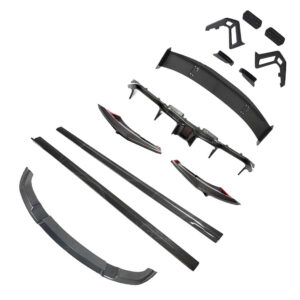 Carbon fiber car body kit pieces laid out, including side skirts, front splitter, rear diffuser, and various aero components.