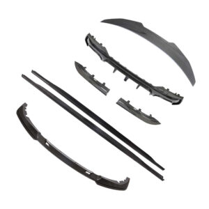 Set of carbon-fiber automotive body parts and trim pieces laid out on a white background