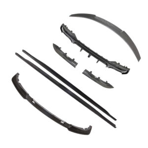 Assorted black carbon-fiber automotive bumper and side trim parts laid out on a white background.