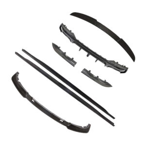 Scattered black car bumper components and trim pieces, including a front lip and side pieces, laid out separately.