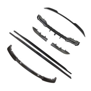 Set of carbon fiber car body kit pieces (diffuser/lip parts) laid out separately, likely for a bumper or aero kit installation