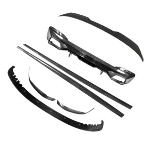 Carbon fiber car aero kit parts laid out, including long side skirts and curved splitters ready for assembly