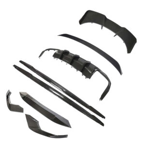 Exploded view of a carbon fiber car aero kit with multiple trim pieces and a front lip, showing bumper, side skirts, and diffuser components laid out separately.
