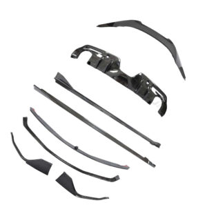 Assorted black carbon-fiber car body parts and trim pieces laid out on a white background.