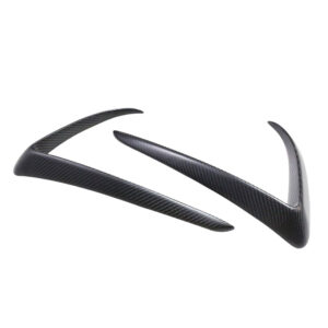 Set of carbon fiber aerodynamic trim pieces for a car, shaped to fit around a spoiler area.