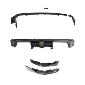 Carbon fiber automotive body kit parts: a curved lip spoiler, a central rear bumper with hitch area, and two lower splitter pieces.