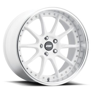 White multi-spoke alloy car wheel with a polished lip and bolts around the rim, viewed at an angle