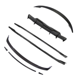 Unassembled set of black carbon-fiber car aero parts laid out on a white background (front lip, side skirts, rear diffuser pieces).