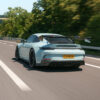 switzerland_porschegt3_1x1_CTCarbon_190626_02_23c410bf-546a-4beb-9302-bb60108ed6c7jpg - OPSHOLDERS Rear view of a light-blue Porsche-style sports car with a large wing, speeding on a highway.