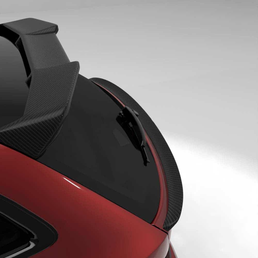 t10jpg - OPSHOLDERS Close-up of a red sports car’s rear window area with a black wiper and carbon-fiber spoiler against a gray background.