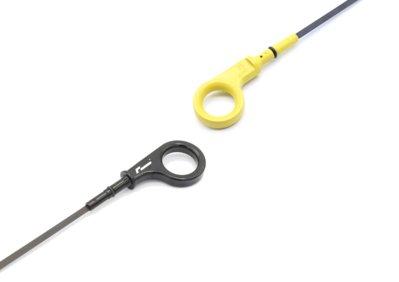 10-14-tsi-billet-dipstick_53399698121_o-scaled-1jpg - OPSHOLDERS Close-up of a yellow loop handle attached to a thin dark rod, with a black circular component nearby on a white background