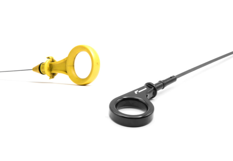 10-14-tsi-billet-dipstick_53399886368_o-scaled-1jpg - OPSHOLDERS Close-up of a yellow ring-shaped medical device attached to a black stethoscope on a white background.