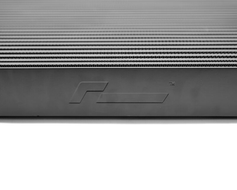 Close-up of the back of a monitor showing horizontal ventilation slits and a partial embossed logo at the bottom edge.