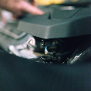 25-tfsi-engine-cover-grommets_53353013810_ojpg - OPSHOLDERS Close-up of a person’s hand adjusting a turntable or DJ mixer, focusing on the control surface.