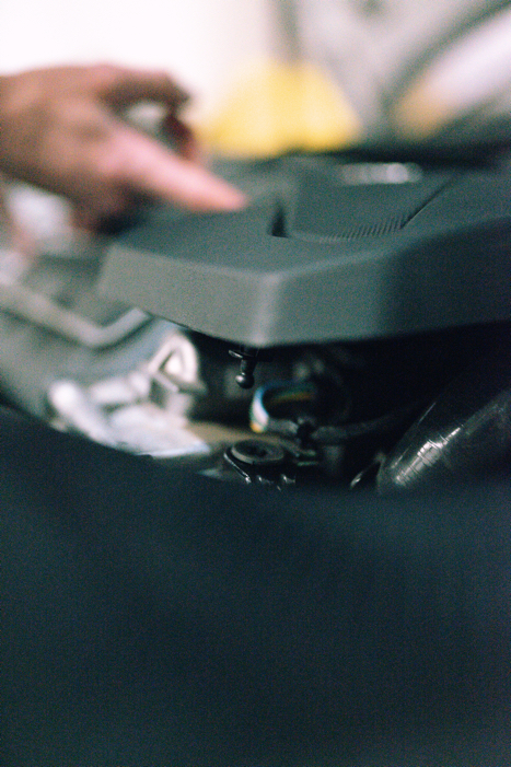 25-tfsi-engine-cover-grommets_53353013810_ojpg - OPSHOLDERS Close-up of a person’s hand adjusting a turntable or DJ mixer, focusing on the control surface.