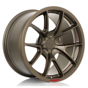 Bronze alloy car wheel with ten spokes and a centered hub cap, photographed on a white background.