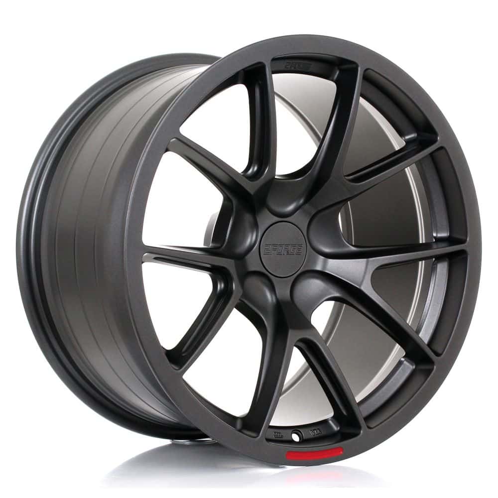 2FORGE_ZF9_MATT_GUNMETAL_1810_ANGLEjpg - OPSHOLDERS Dark gray alloy car wheel with a multi-spoke design and a small red accent near the rim.