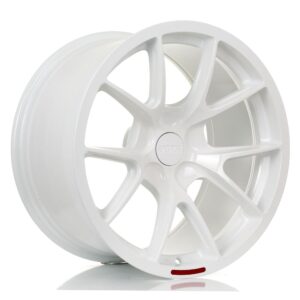 White multi-spoke alloy car wheel with a centered hub and a small red rim accent, viewed at an angle to show depth.