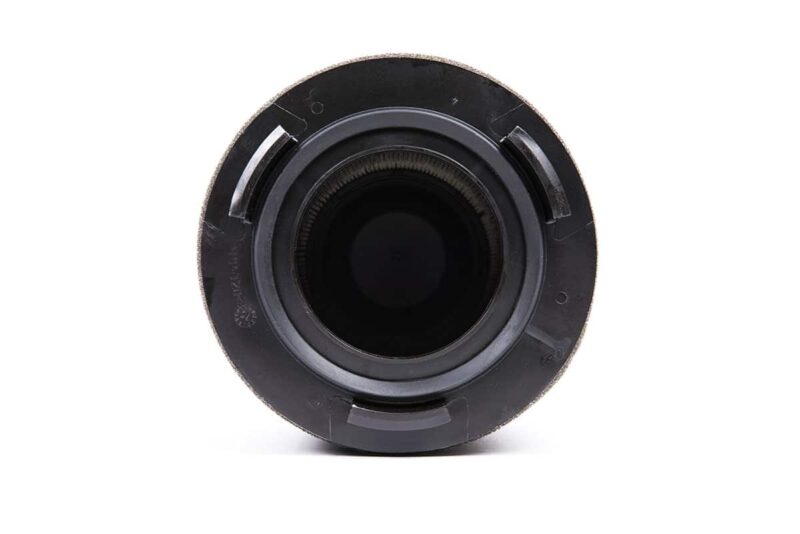 3-73-1jpg - OPSHOLDERS Close-up view of a camera lens opening facing the viewer, showing the circular mount and dark interior.