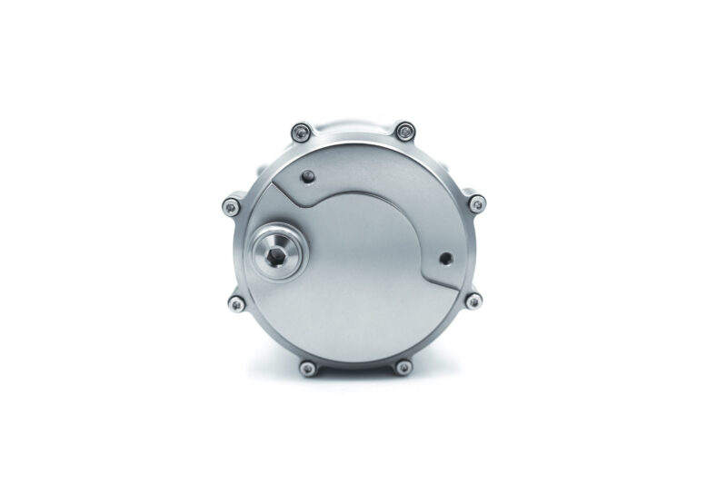 Close-up of a metallic circular gearbox-style cover with screws around its edge on a white background, viewed from the front.