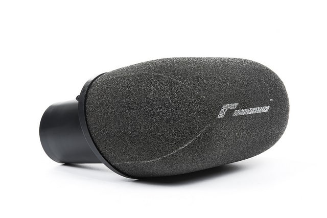36949082233_1e71959c92_z__476401517224298-1jpg - OPSHOLDERS Close-up of a black microphone with a foam windscreen on a white background.