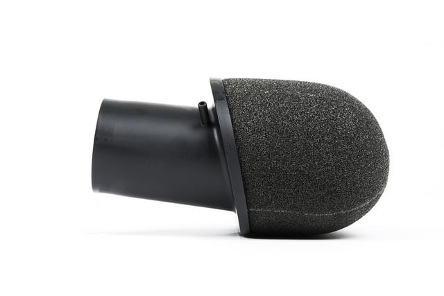 37571202136_77b27710c4_z__388761517224298-1jpg - OPSHOLDERS Close-up of a black microphone with a foam windscreen on a white background