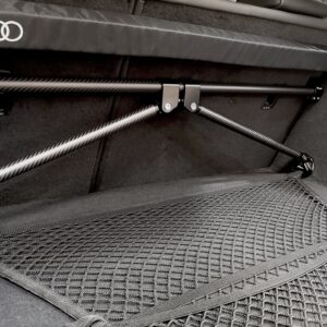 50813847421_e2fe8ff419_k-2jpg - OPSHOLDERS Interior of a car trunk with carbon-fiber support rails, a mesh cargo net, and an Audi logo trim edge.