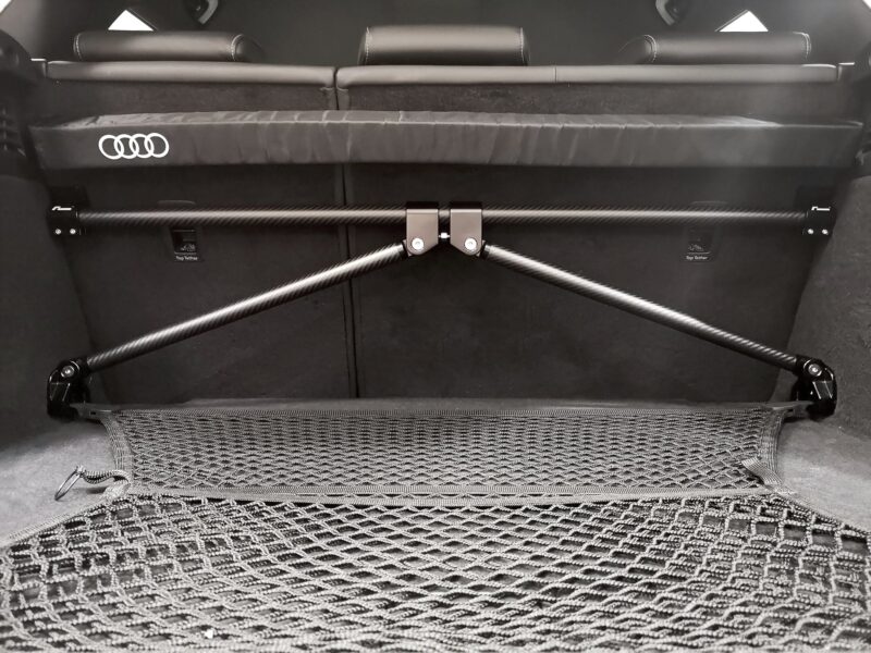 50813847631_db216464c6_k-1jpg - OPSHOLDERS Rear cargo area of an Audi with a wide padded crossbar and carbon-fiber support rods across the opening, seats folded in the back