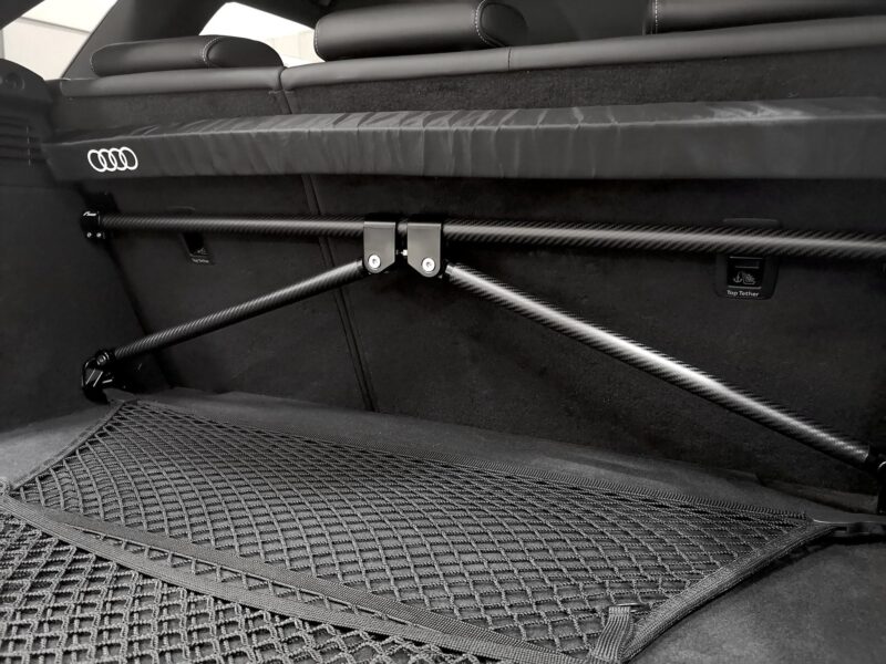 50813847836_b3fda649c0_k-1jpg - OPSHOLDERS Audi-branded cargo area with carbon fiber rails and a textured cargo net in a dark trunk.