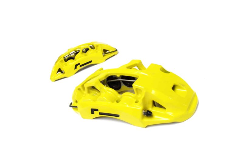Bright yellow cycling helmet shells with vents on a white background.
