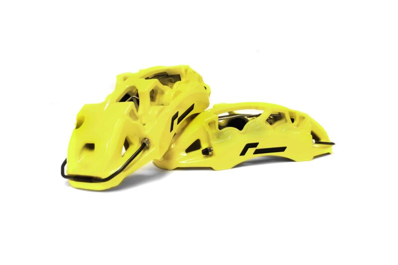 Two bright yellow bicycle helmets with black chin straps, stacked together on a white background.