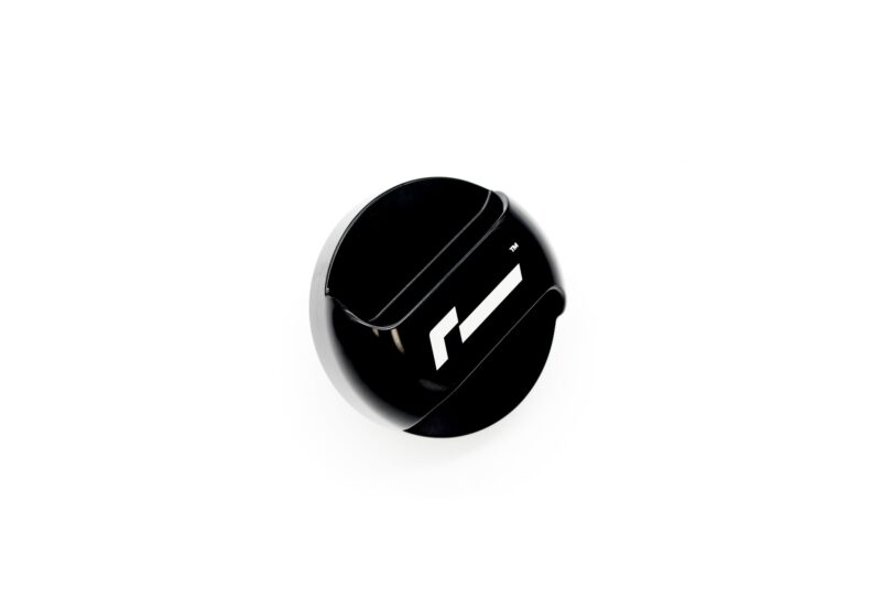 Close-up of a glossy black circular object with white diagonal stripes on a white background.