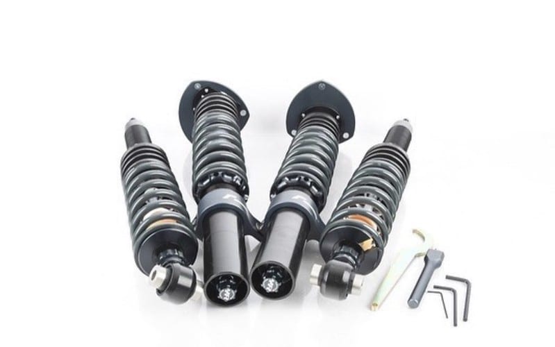 52424668196_4a205a4e07_c-1jpg - OPSHOLDERS Set of adjustable coilover shocks with mounting flanges and small Allen wrenches for installation, laid out on a white surface.