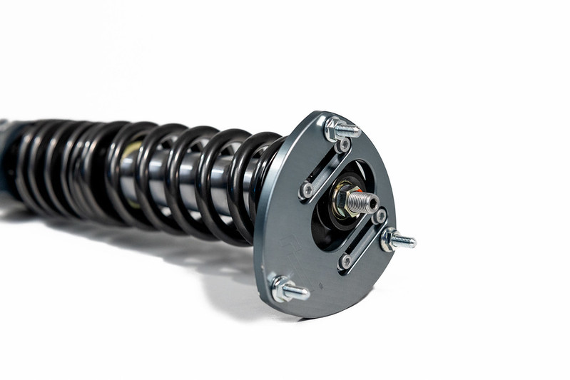 52424669611_c2b496e5e5_c-1jpg - OPSHOLDERS Coilover shock absorber with a helical spring and mounting plate against a white background, car suspension component