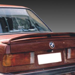 Rear view of a brown vintage BMW with a small spoiler and a blanked license plate against a gray gradient background.