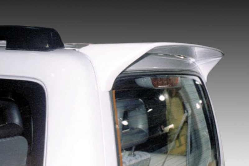 A-157_2jpg - OPSHOLDERS Close-up of a white van's rear corner showing a roof spoiler and the passenger-side window