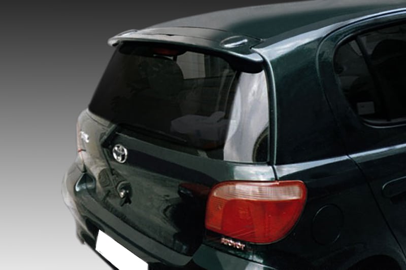A-161_1jpg - OPSHOLDERS Rear view of a dark green hatchback car, showing the trunk, bumper, and red taillight assembly.