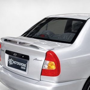 Rear of a silver Hyundai Accent with a large rear spoiler and red tail lights in a studio setting