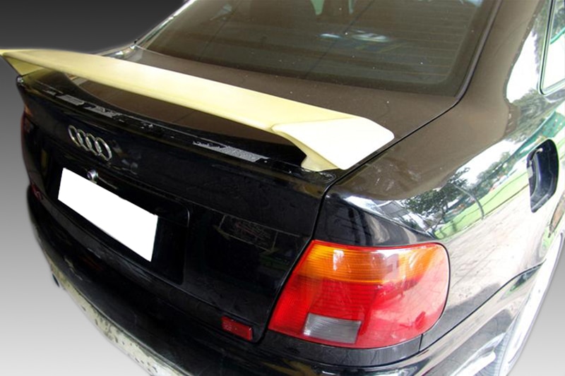 A-179_1jpg - OPSHOLDERS Rear view of a black Audi with a beige spoiler, visible taillights, and a white license plate area.
