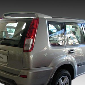 Rear three-quarter view of a silver Nissan X-Trail SUV showing the back and right side doors (urban setting reflected in windows).
