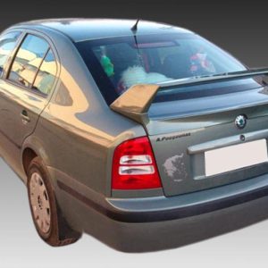 Grey sedan viewed from the rear-left with a large rear spoiler on a gradient backdrop.