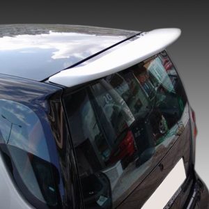 Rear three-quarter view of a silver hatchback showing a spoiler and tinted rear window, parked with reflections in the glass