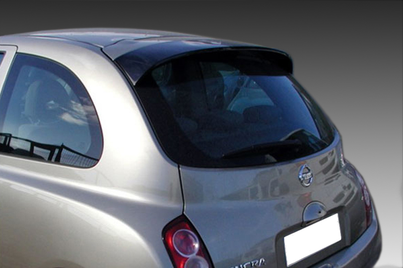 A-247_1jpg - OPSHOLDERS Rear view of a silver Nissan hatchback, showing tail lights and curved rear window against a dark gradient background.