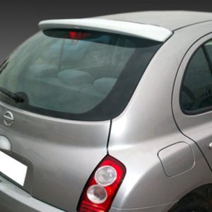 Rear three-quarter view of a silver Nissan hatchback photographed against a gray gradient background.