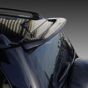 Close-up of a black car's rear spoiler and curved roof with a reflective surface.