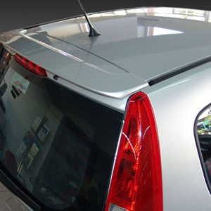 Silver hatchback car rear-side view, showing red taillight, rear window, and antenna on the roof.