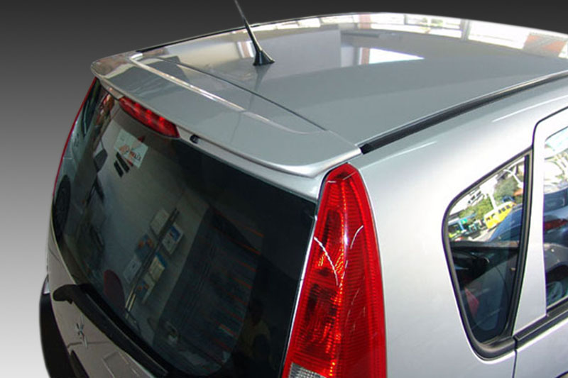 A-276_1jpg - OPSHOLDERS Silver hatchback car rear-side view, showing red taillight, rear window, and antenna on the roof.